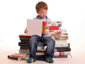 boy sitting stack books reading learning studying min